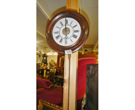A post office alarm clock with weights and pendulum.