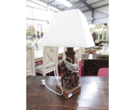 A carved black forest table lamp with shade.