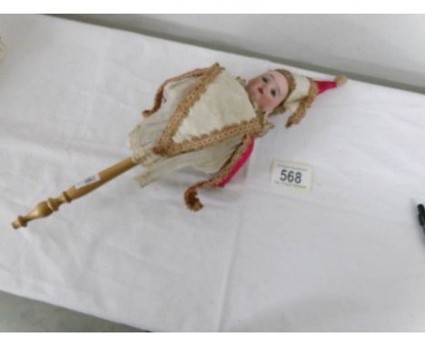 An antique bisque headed doll on stick.