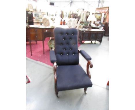 A Victorian mahogany adjustable arm chair with deep button back.