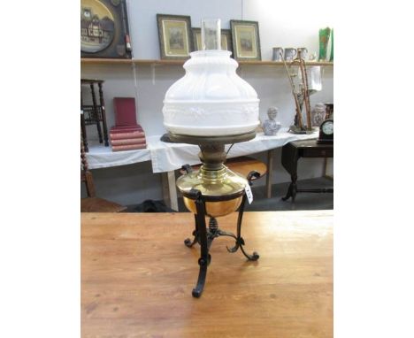 An arts and crafts oil lamp, circa 1910.  A blacksmith made, black painted, wrought iron tripod stand holding a polished bras