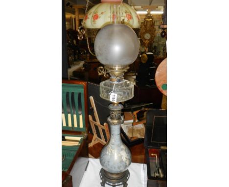 A tall French decorative oil lamp, circa 1915.  The base could be glass or ceramic with white flowers on a pale blue backgrou