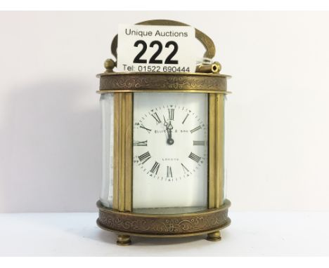 An oval chased brass carriage clock marked Elliot &amp; Son, London, in working order.