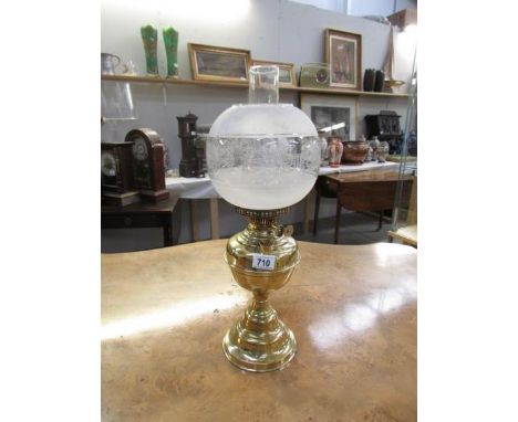 An Edwardian all brass oil lamp with twin wick burner, reproduction 1970's shade and correct chimney.