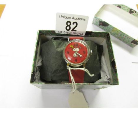 A Timex watch with Snoopy and Peanuts featuring a red dial with hour hand.  Manual wind.  1958-65.  In very good condition an