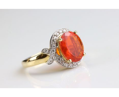 Fire opal and diamond 18ct yellow and white gold set gold ring, the oval mixed cut fire opal measuring approx 10mm x 8mm, fou