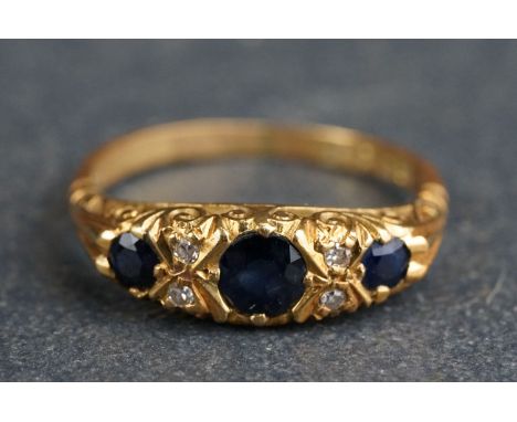 Sapphire and diamond 18ct yellow gold boat head ring, three graduated round mixed cut blue-black sapphire, four small eight c