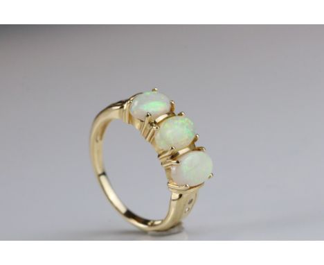 Opal three stone 14ct yellow gold ring, three oval cabochon cut precious white opals displaying green, yellow and orange play