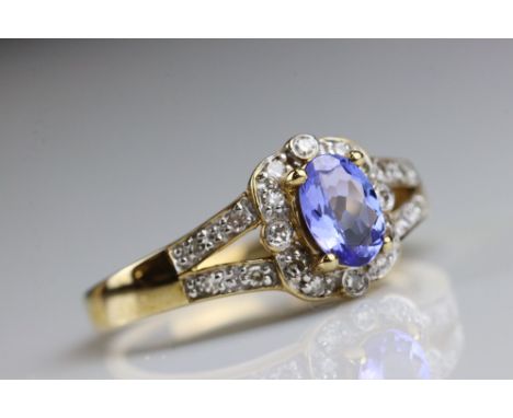 Sapphire and diamond 9ct yellow gold cluster ring, the oval mixed cut sapphire measuring approx 6.5mm x 4.5mm, twelve small r