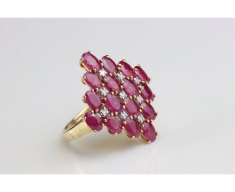 Ruby and diamond 9ct yellow gold cluster ring, the marquise shaped head set with sixteen oval mixed cut rubies, nine small ro