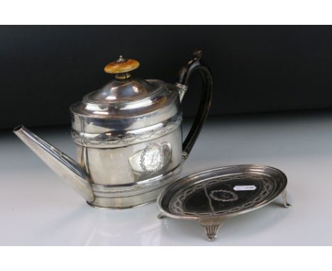 George III silver teapot and stand, the elongated oval body with repoussé bands, bright cut garland and pin-prick decoration 