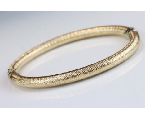 9ct yellow gold hinged bangle, textured rounded body 