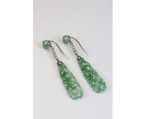 Pair of early 20th century jade and diamond drop earrings, the caved jade dropper depicting bird and foliage, suspended from 