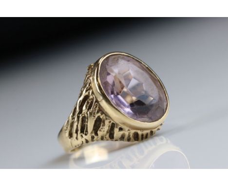 Amethyst unmarked yellow gold ring, the pale oval mixed cut amethyst measuring approx 13.5mm x 9.5mm, collet setting, texture