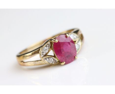 Ruby and diamond 9ct yellow gold ring, the oval mixed cut ruby measuring approx  8mm x 6mm, the leaf motif shoulders each set