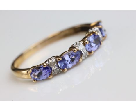 Tanzanite and diamond 9ct yellow gold ring, four oval mixed cut tanzanite, each measuring approx 5mm x 3mm, six small round e