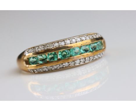 Emerald and diamond 9ct yellow gold ring, eight small round mixed cut emeralds to centre, channel settings, a row of small ro