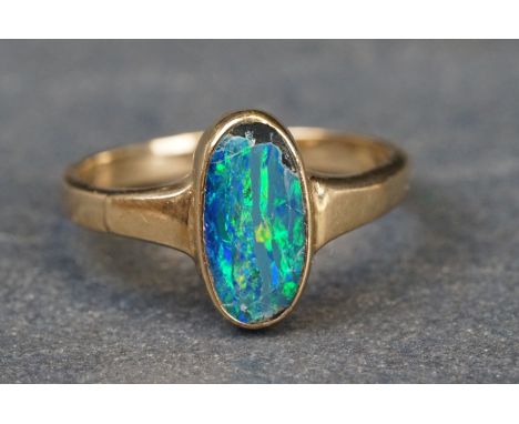 Black opal doublet 9ct yellow gold ring, the oval black opal doublet measuring approx 11.5mm x 6mm, collet setting, tapered s