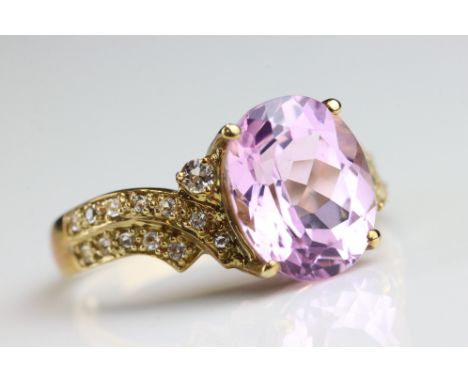 Kunzite and white topaz 9ct yellow gold ring, the oval mixed cut kunzite measuring approx 11mm x 9mm, four claw setting, smal