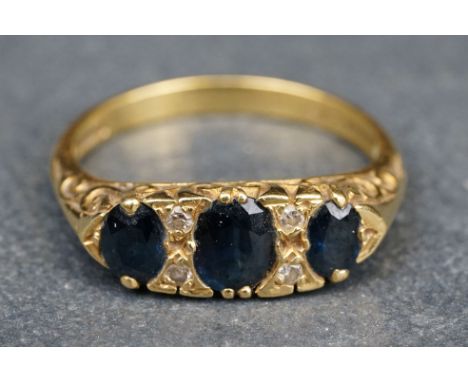 Sapphire and diamond 18ct yellow gold ring, three graduated oval mixed cut blue sapphires, the principle sapphire measuring a