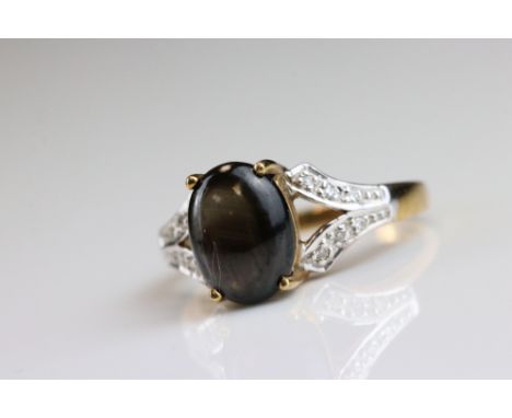 Black star sapphire and diamond 9ct yellow and white gold set ring, the oval cabochon cut black star sapphire measuring appro