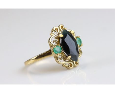 Sapphire and emerald 9ct yellow gold ring, the marquise cut blue-green sapphire measuring approx 12mm x 6mm, small round mixe