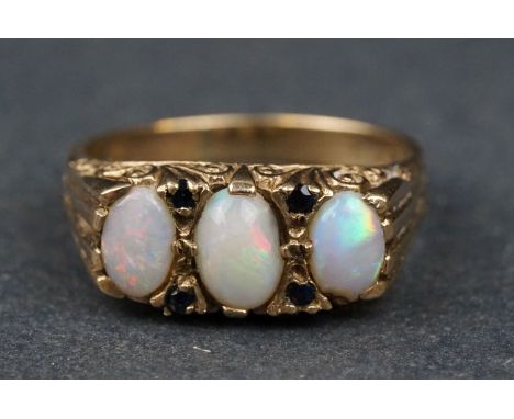 Opal and sapphire 9ct yellow gold boat head ring, three graduated oval cabochon cut precious white opals, violet, green and r