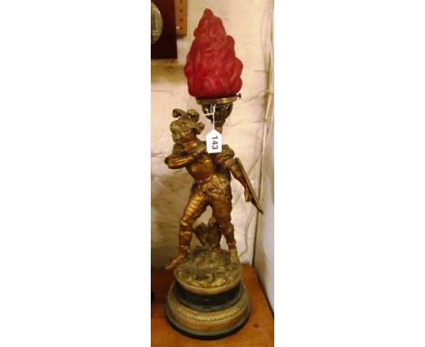 A gilt lamp warrior holding shield and red torch light
