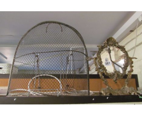 A brass fireguard and oval toilet mirror