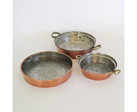Three Cypriot copper tin lined pans, two with brass handles and one with moulded rim. The largest with handles W37cm (3)
Prov