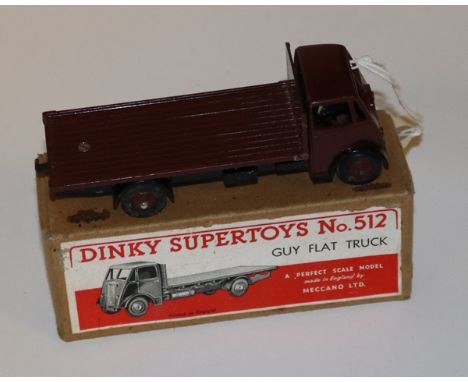 A Dinky Supertoys Guy Flat Truck (512). An example with Maroon cab, flatbed and wheels, black chassis and wings. Boxed, minor