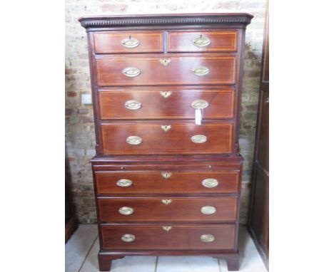 A Georgian mahogany and crossbanded chest on chest with oak lined drawers canted corners and a brushing slide raised on brack