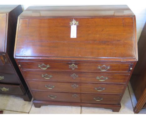 A Georgian mahogany bureau with four drawers and fitted interiors standing on bracket feet - 103cm tall x 99 x 55cm deep