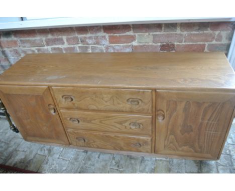 A blonde Elm Ercol sideboard with three central drawers flanked by cupboard doors, 67cm tall x 153cm x 46cm - good condition,