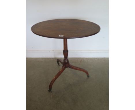 A 19th Century mahogany tilt top oval wine table on a tripod base - 71 cm tall x 61 cm x 42 cm - on brass caps and casters - 