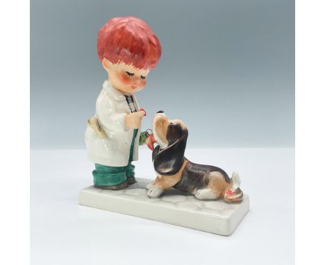Features a boy in a white coat giving his cute dog medicine. Hummel backstamp TMK 4. Issued: 1964-1972Dimensions: 4.75"L x 2"