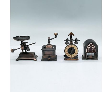 Four bronze colored metal pencil sharpeners modelled as mini versions of a radio, industrial clock, scale and coffee grinder.