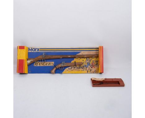 This is a vintage cap gun modeled after an early weapon and made of plastic and metal. Affixed to its original cardboard pack