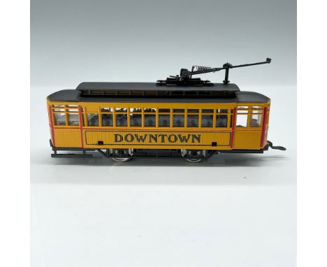 This is a highly detailed trolly car in HO scale with yellow sides with red detail and black top. It is marked Downtown on th