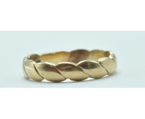 A 9ct gold wedding band ring of twist design. Rubbed hallmarks to the interior of the band, marked 375 with crown mark. Weigh