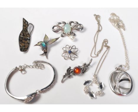 A collection of silver 925 ladies jewellery to include brooches of various shapes and sizes, silver and enamel brooches, neck