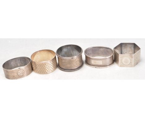 A group of five 20th Century silver hallmarked napkin rings to include various shapes and sizes, most with engine turned deco