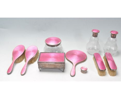 A 1920’s silver and guilloche enamel dressing table set. The set comprising of brushes, hand mirror, powder pot, perfume bott