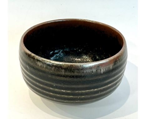 David Leach, OBE (1911-2005): a studio pottery earthenware bowl - ribbed circular form with short circular foot, in a dark an
