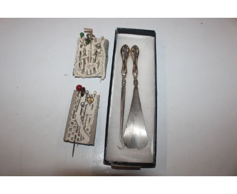 A silver handled shoe horn and button hook; and a collection of yellow metal and other stick pins