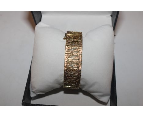 A gilt metal bangle, signed
