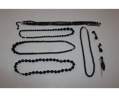 A box of jet and jet style jewellery, including necklaces, stick pin and ear-rings