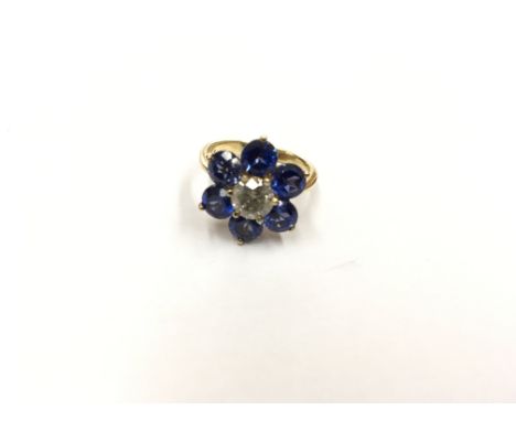 18ct Gold Ladies ring set with a central round brilliant cut diamond flanked by vivid blue stones. Ring size M.