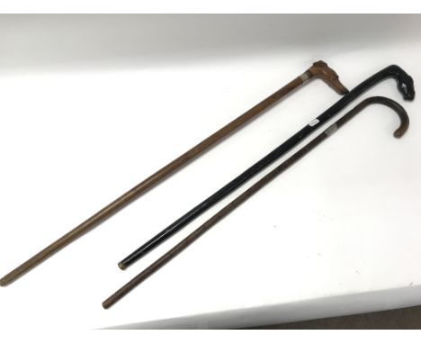 Three vintage walking sticks; one carved in the form of a dogs head and another a horses head.