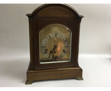 A wooden German made cased mantle clock.